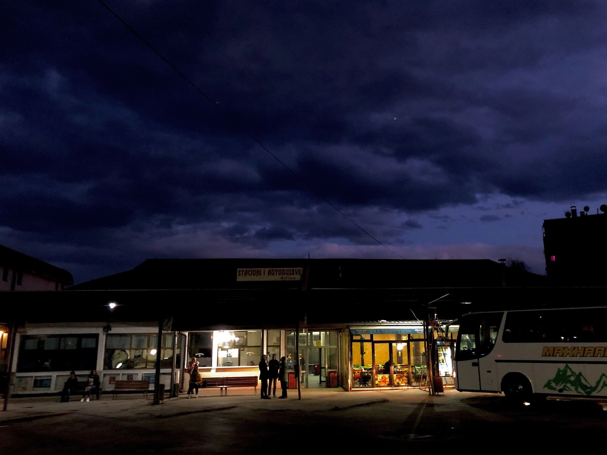 Bus station at dusk under a stormy sky